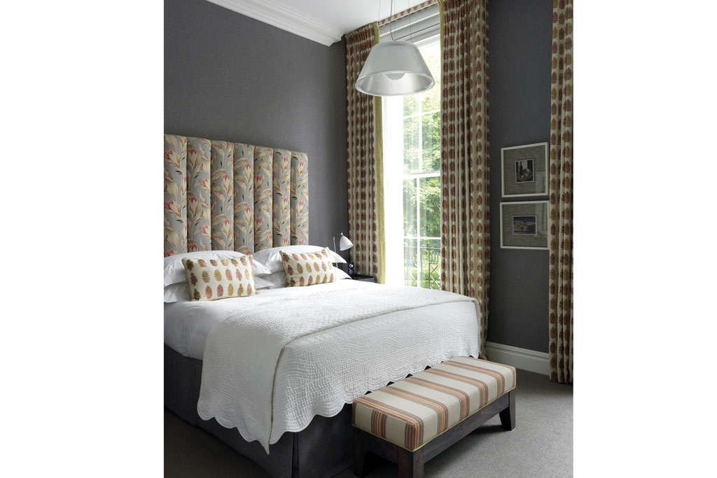 Hotel bedroom with white sheets and light brown accents