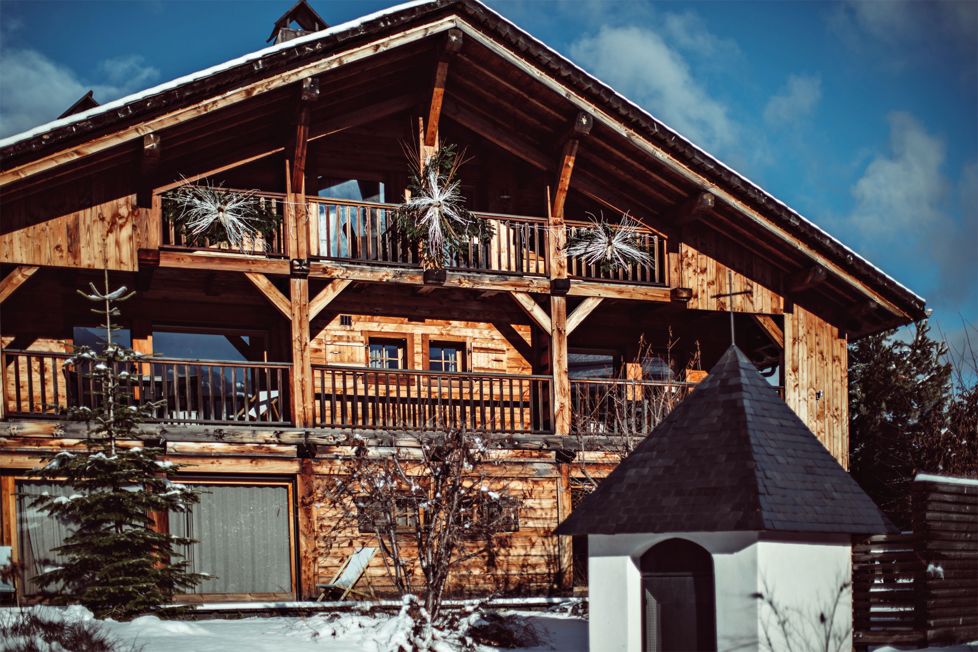 The exterior of the Alpaga Hotel with snow covered trees in front