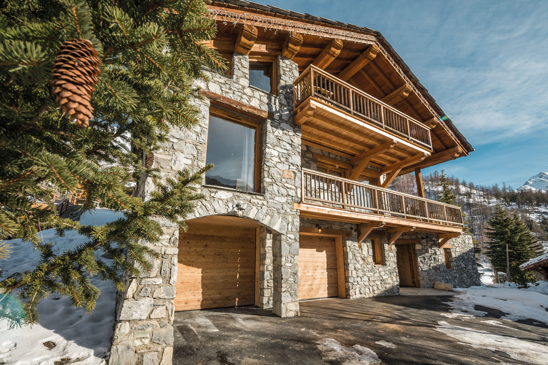 Chalet Blackcomb;s exterior - it is three stories tall with balconies on the first and second floor, with stone pillars framing the garage