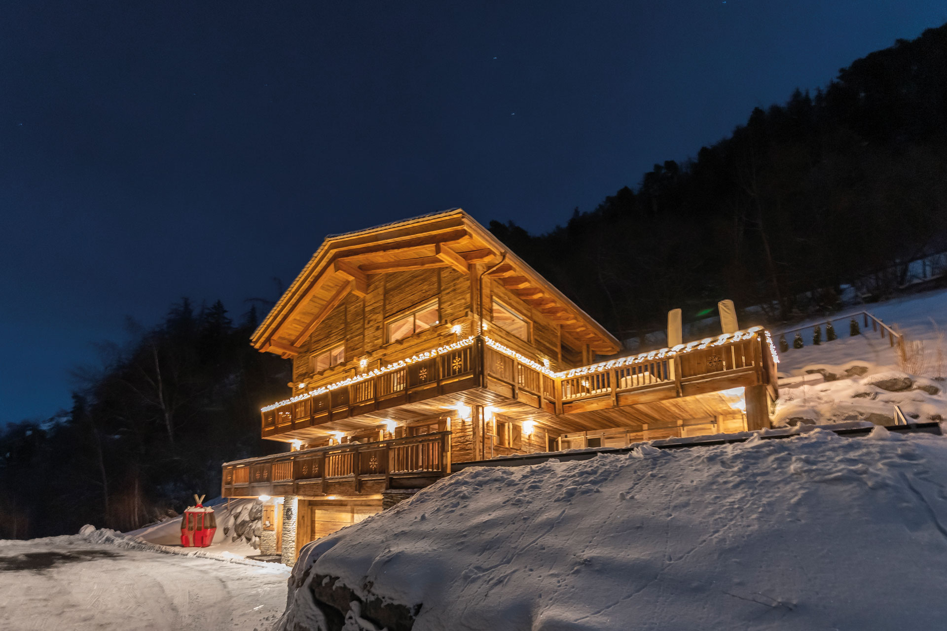 Chalet V is a timber building set in the snow, here lit up by underlighting