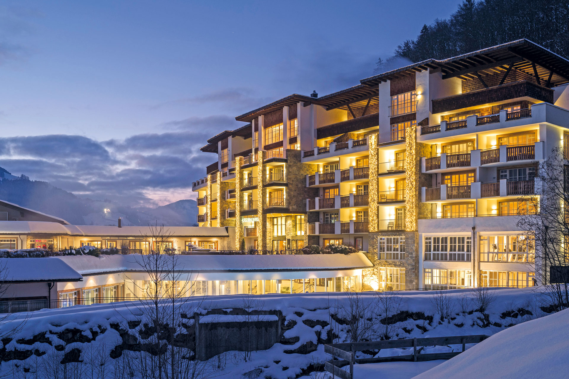 The Grand Tirolia hotel's exterior lit up at night. It is a multistory, very large building