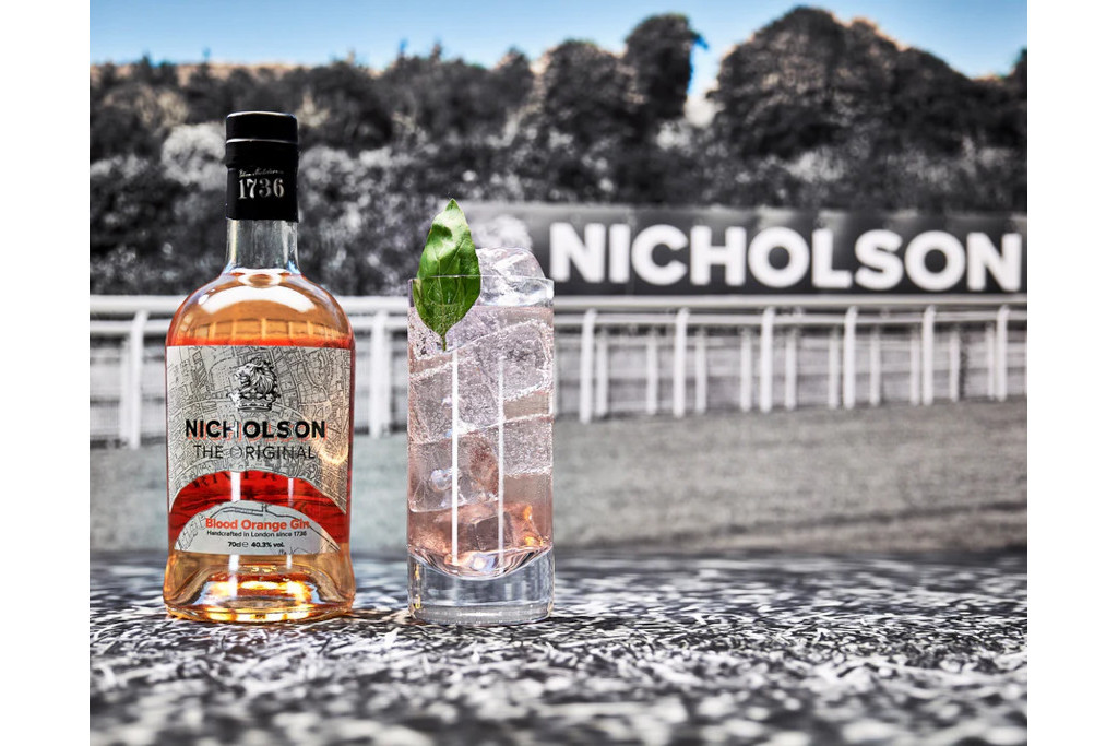 Bottle of Nicholson Blood Orange Gin Gin next to a cocktail with a racecourse in the backgorund