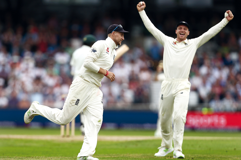 Joe Root celebrates a catch two men