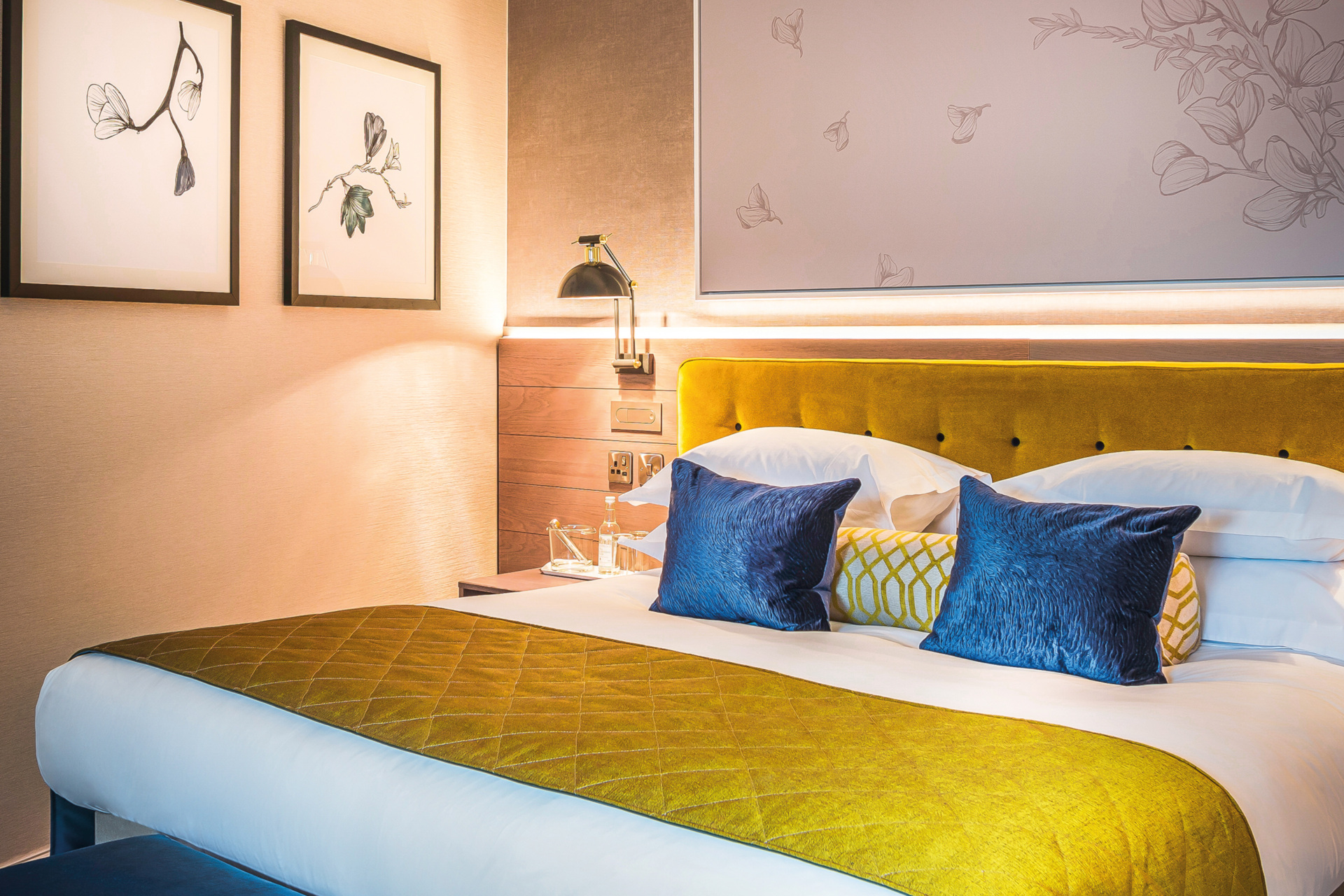 Bed with yellow topper and blue cushions