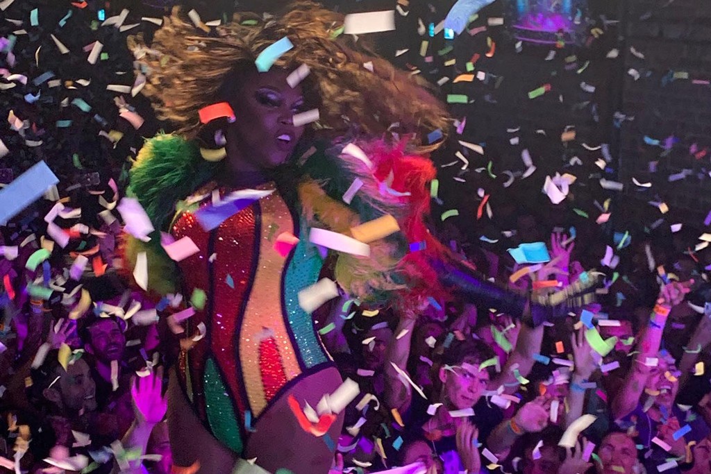 A performer dancing in a gay bar with confetti