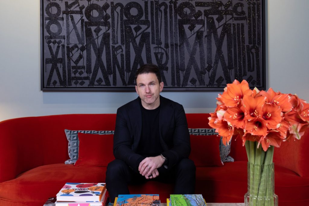 Art advisor, John Russo sat on a red sofa