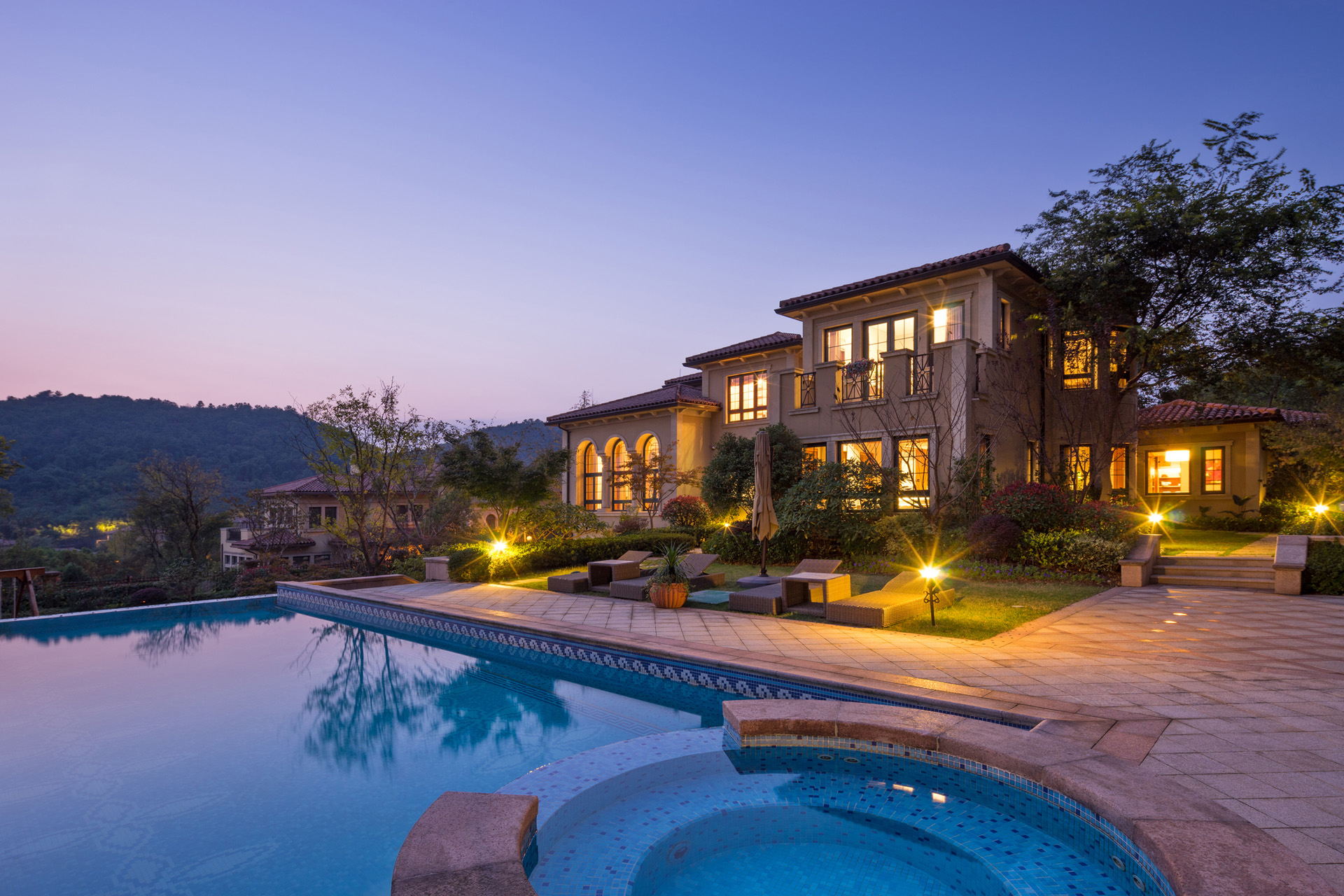 night scene of modern waterfront villa with meadow outdoors and illuminated sky