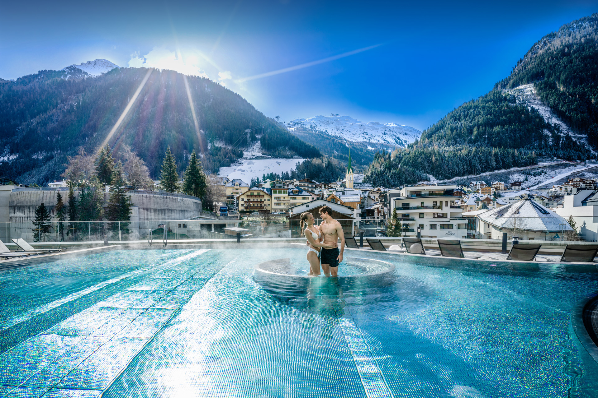 A couple in a pool backdropped by mountains