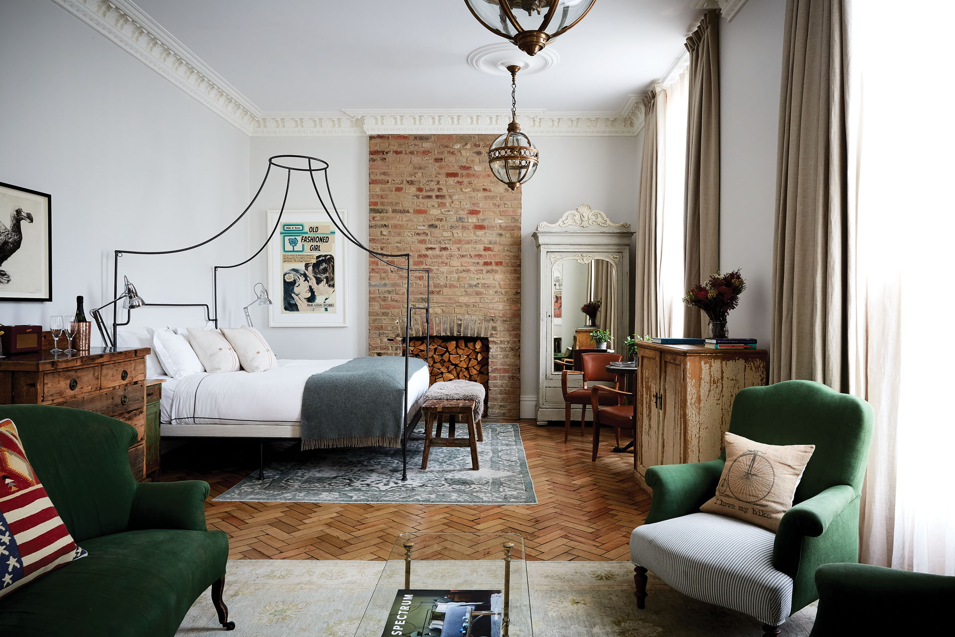 Bedroom with green armchairs and four poster bed