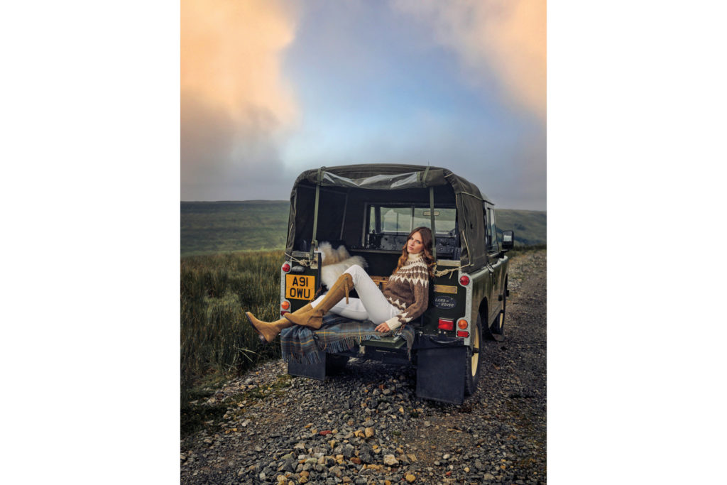 Woman lounging in the back of an uncovered jeep
