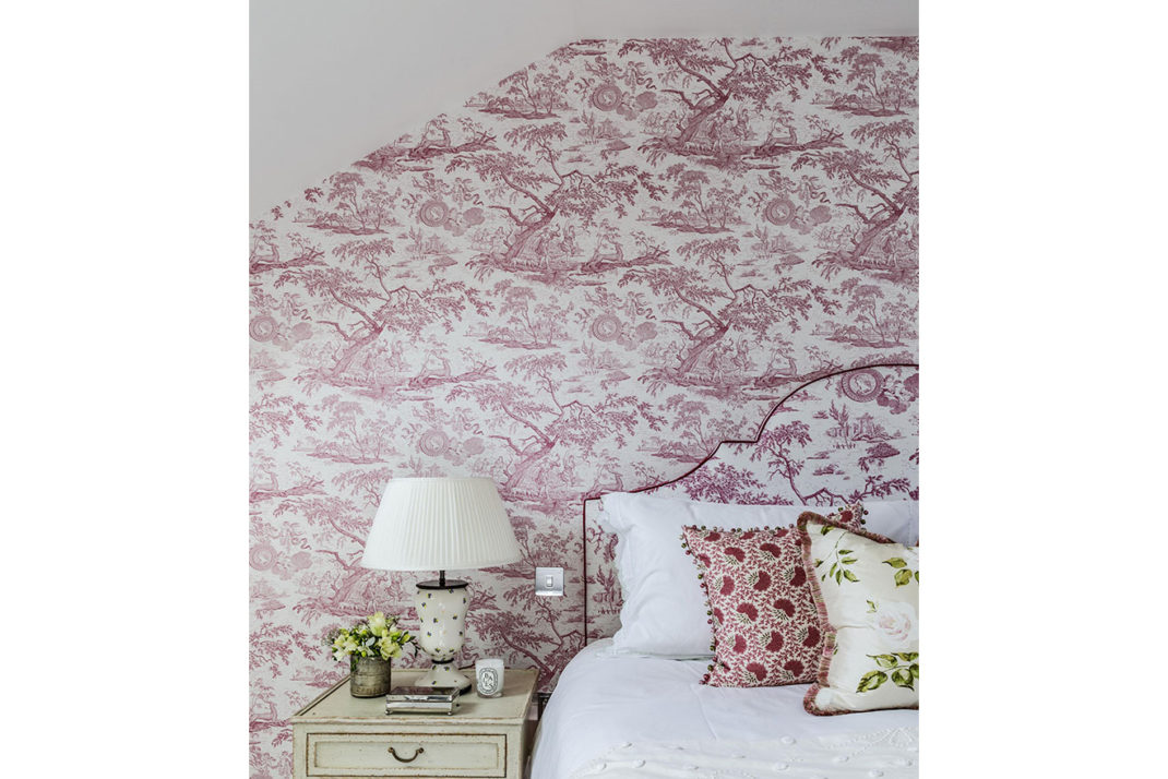 Bedroom with pink toile de juoy wallpaper and headboard