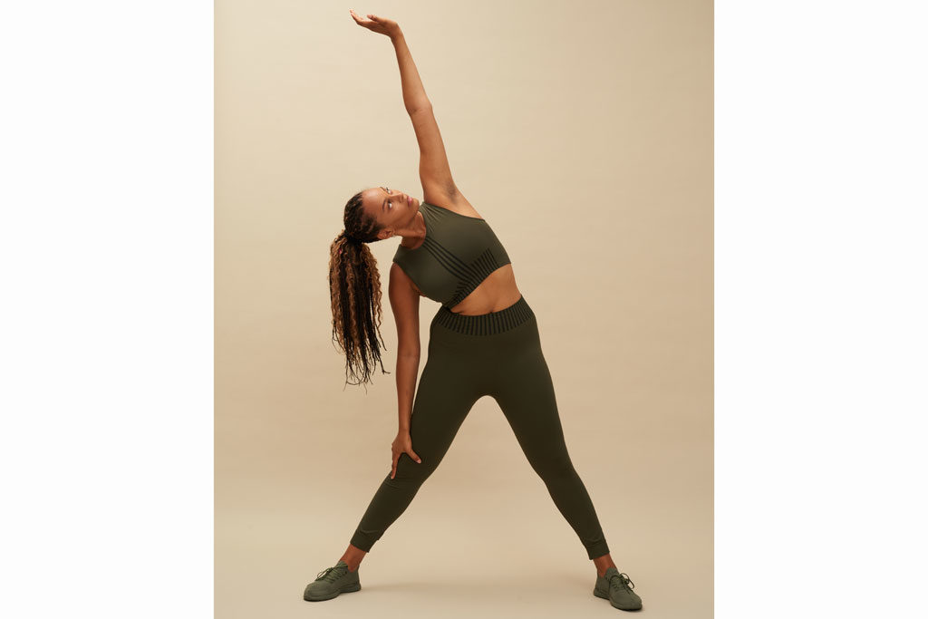 Woman in activewear stretching an arm over her head (sustainable activewear brands)