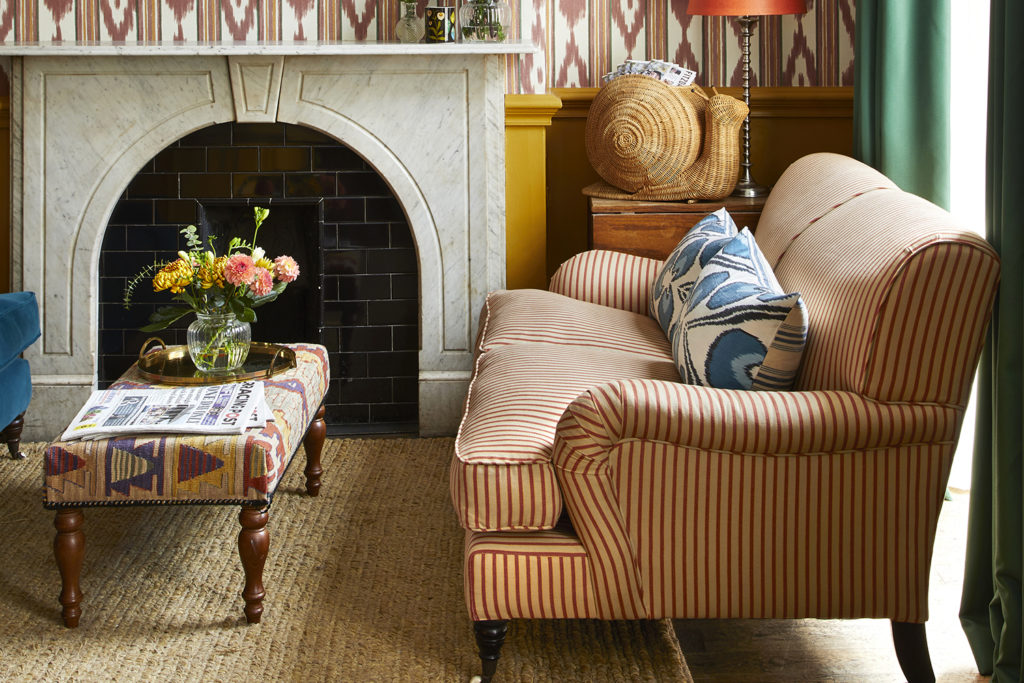 Fitzdares sitting room with striped sofa and fireplace