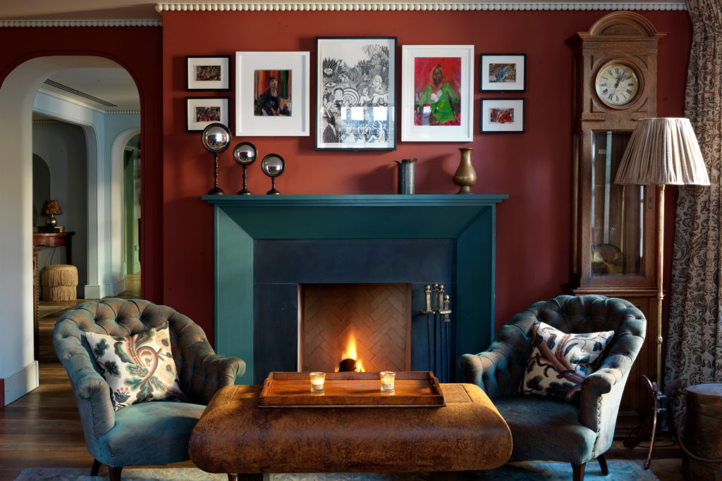 Soho Greek street red drawing room with two chairs and fireplace