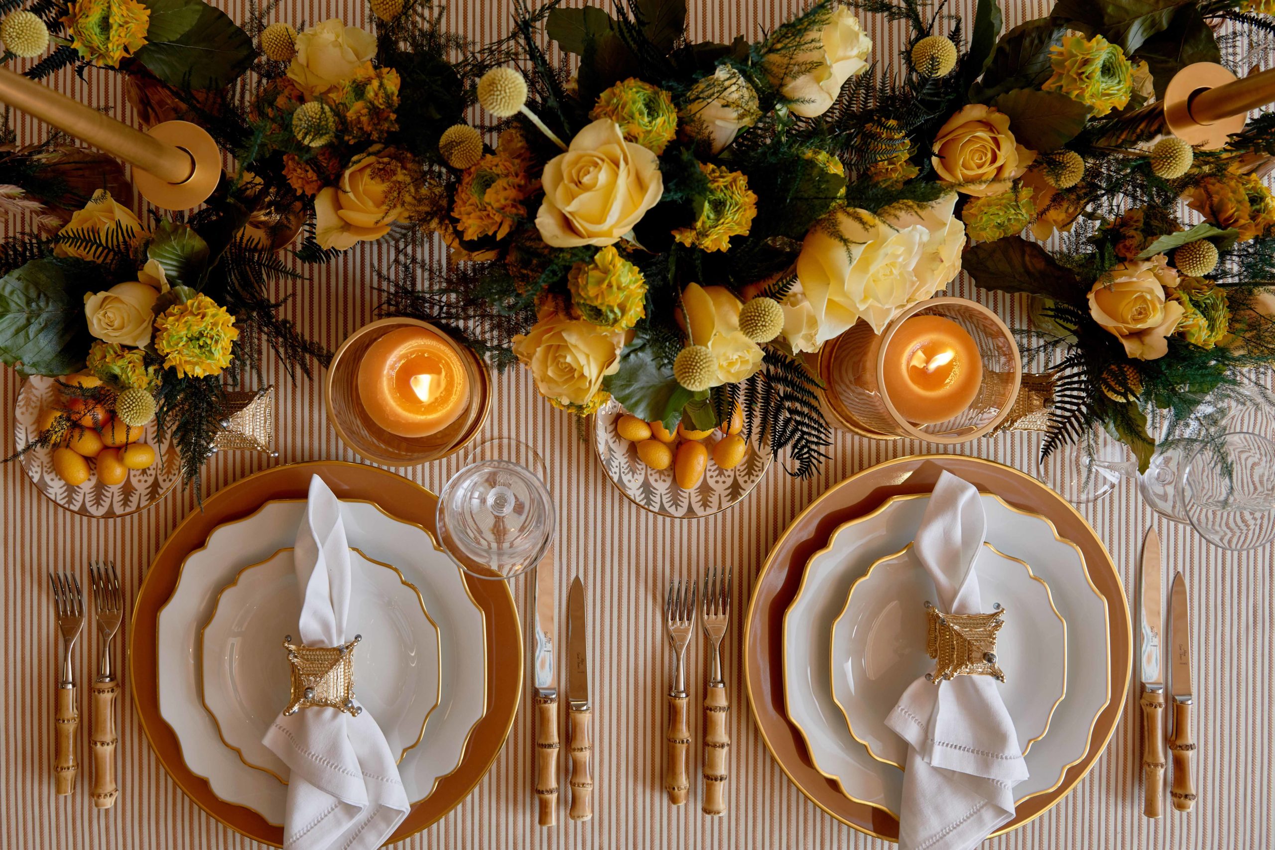 Two Bonadea gold and orange table settings with orange and peach centrepiece
