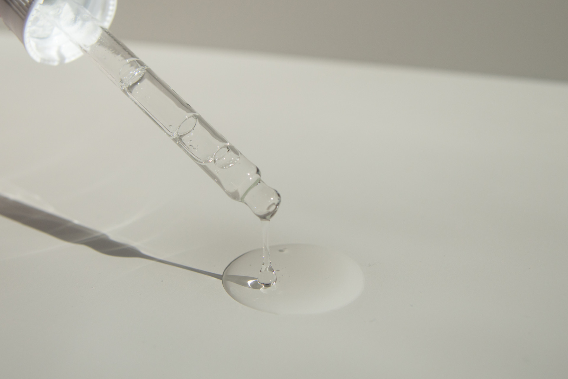 Pipette dropping oil onto grey surface