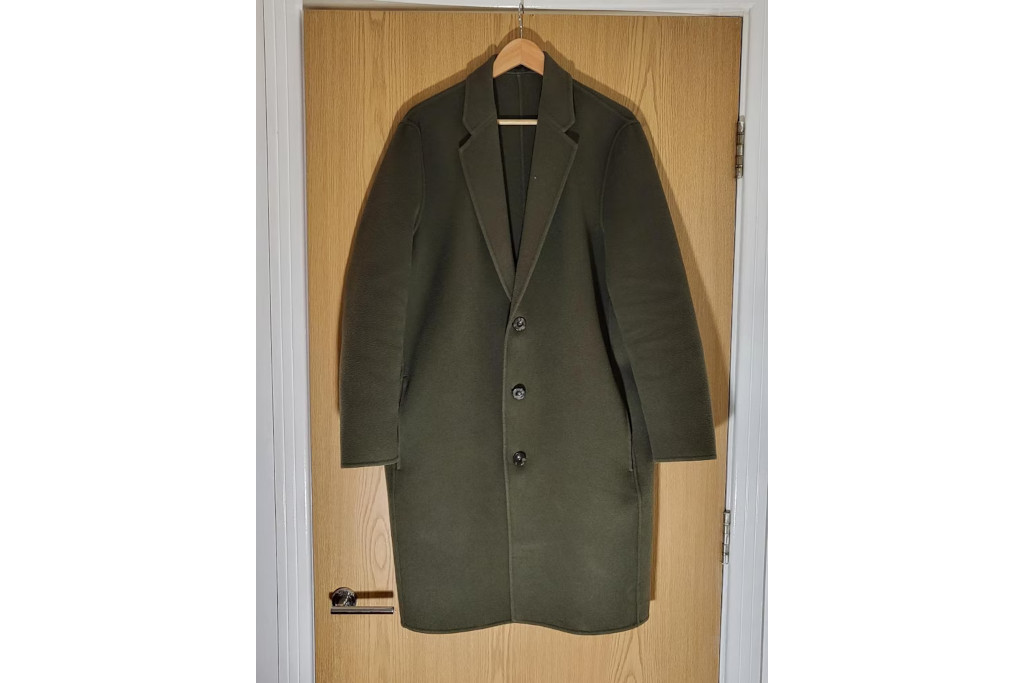Green coat hung on door