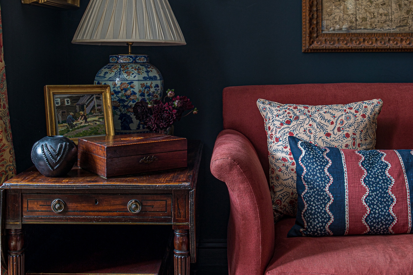 Red sofa and side table detail with lamp