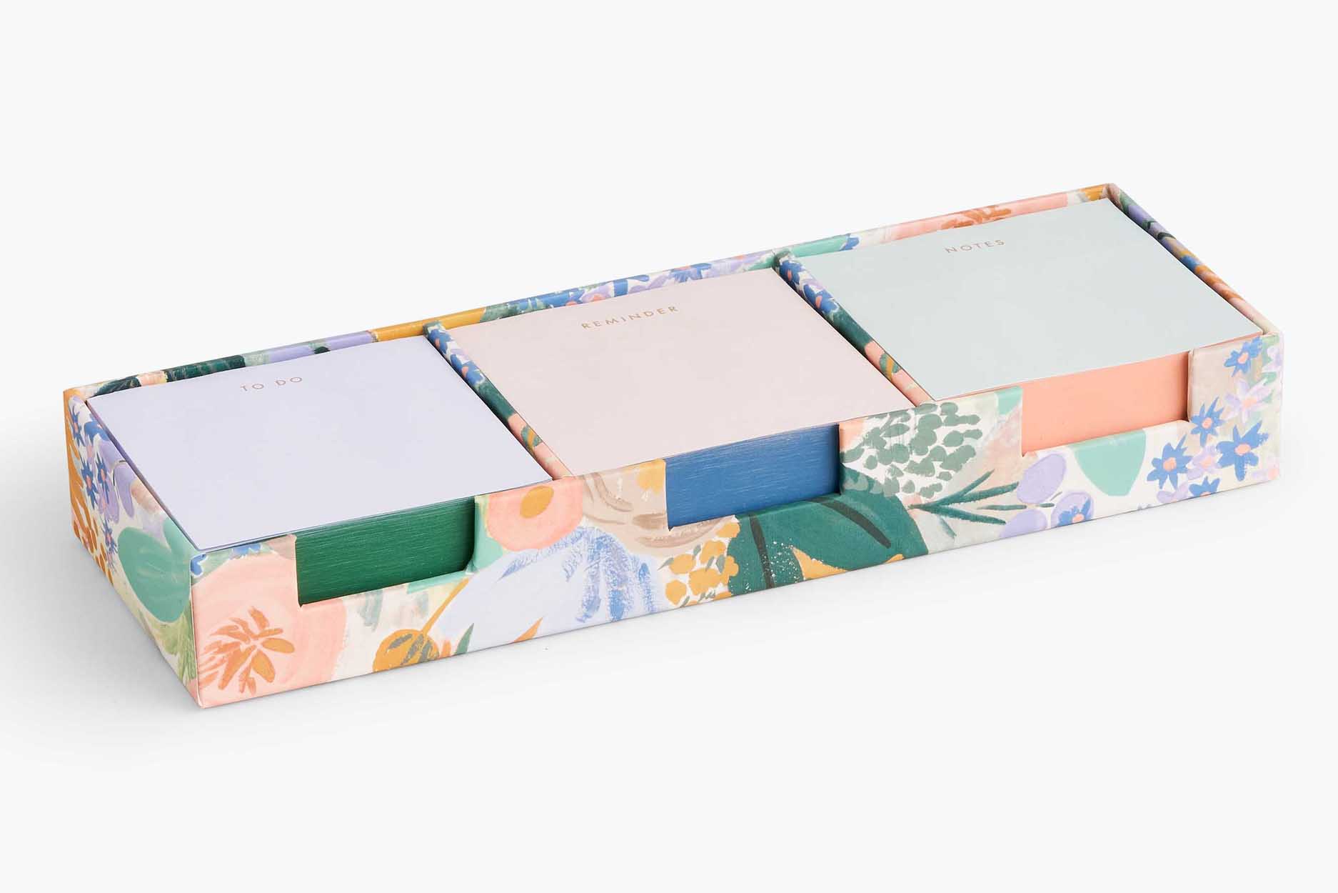 Three sets of multicoloured post it notes in patterned holder