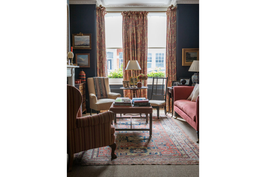 Navy sitting room with two armchairs and red sofa