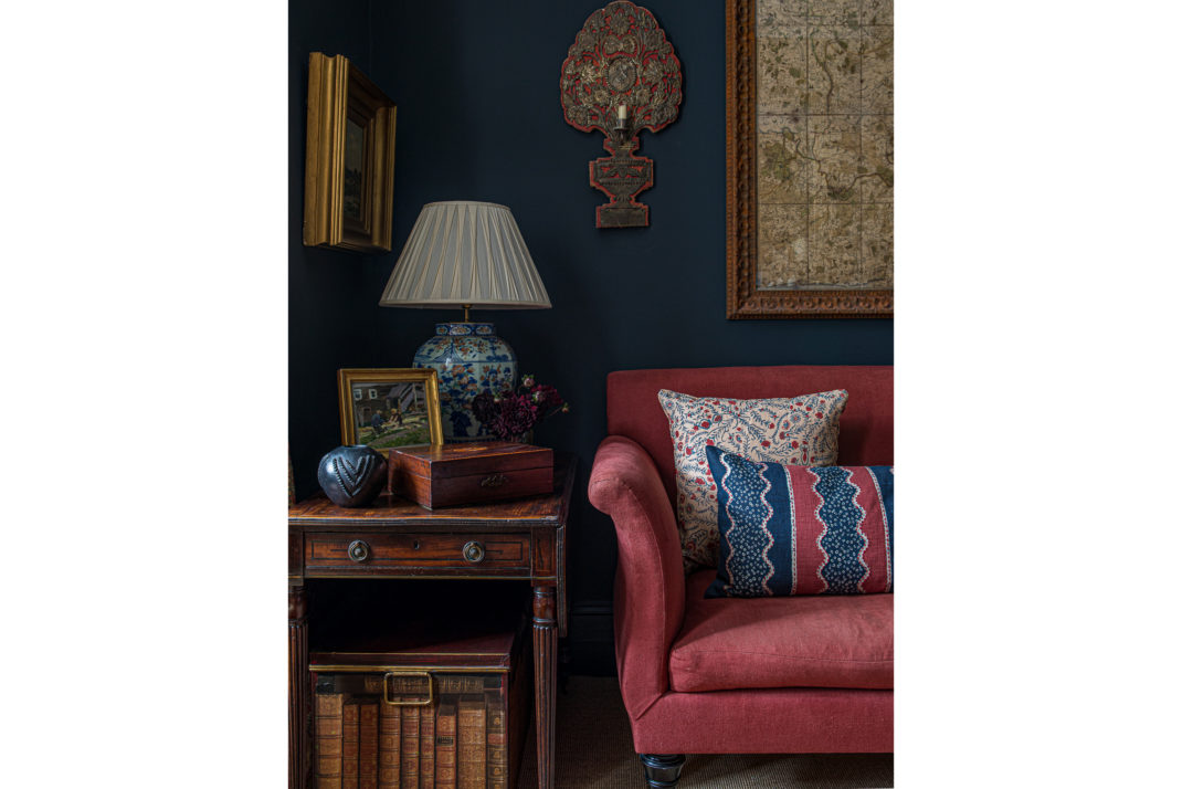 Red sofa and side table detail with lamp