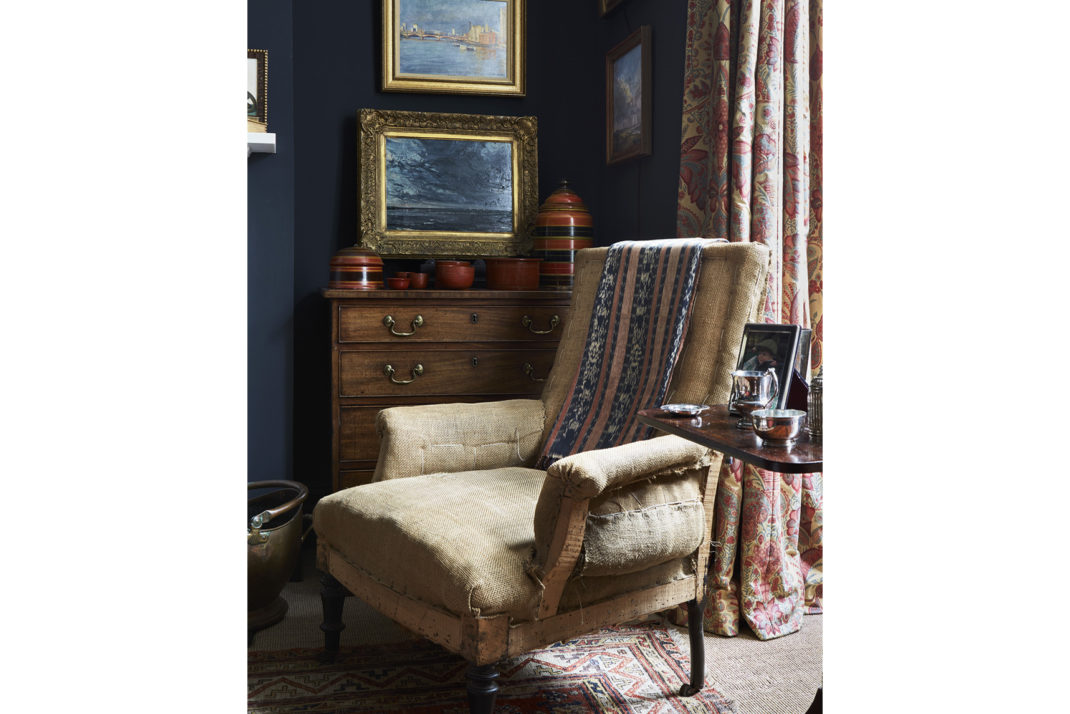 Beige armchair in navy painted room 