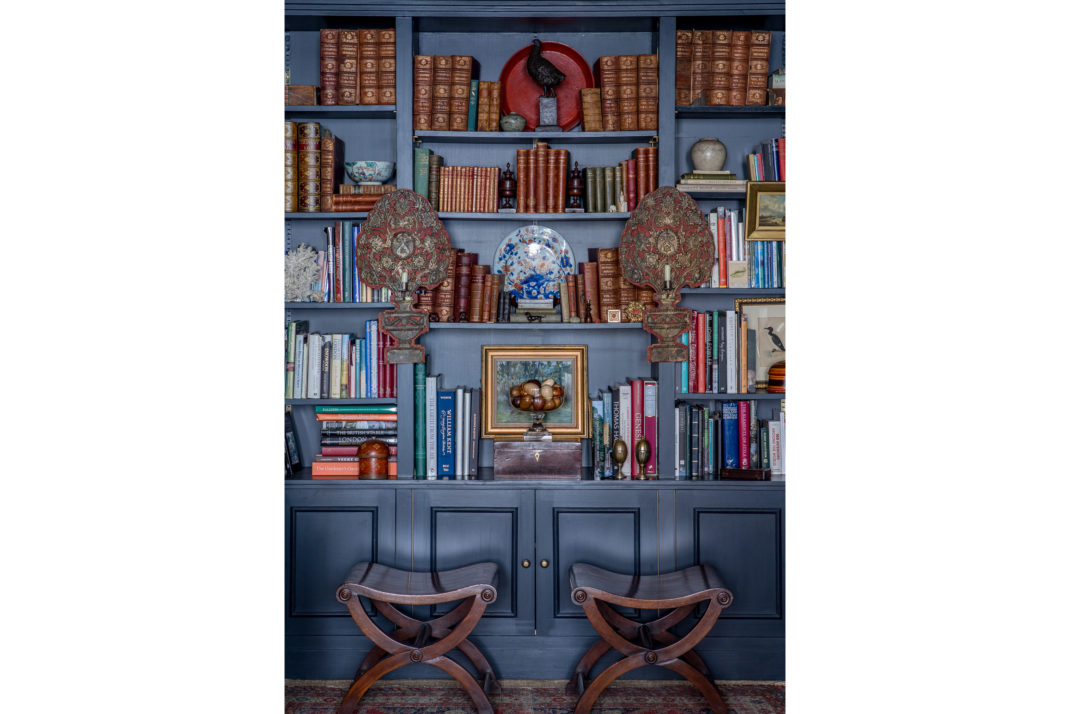 Navy blue bookcase and two wooden stools