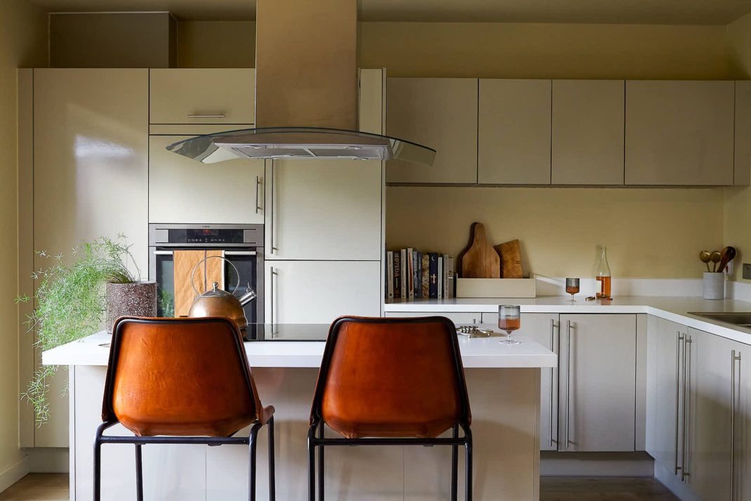 Neutral kitchen with two orange bar stools