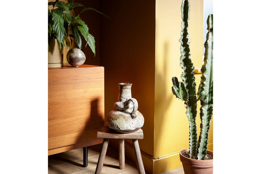 Decor corner, yellow walls, plants and ceramics