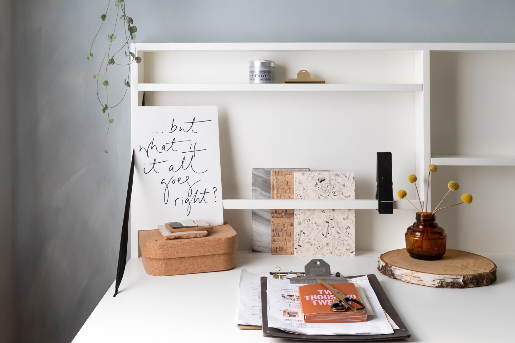 White minimal desk with art print, grey wall background