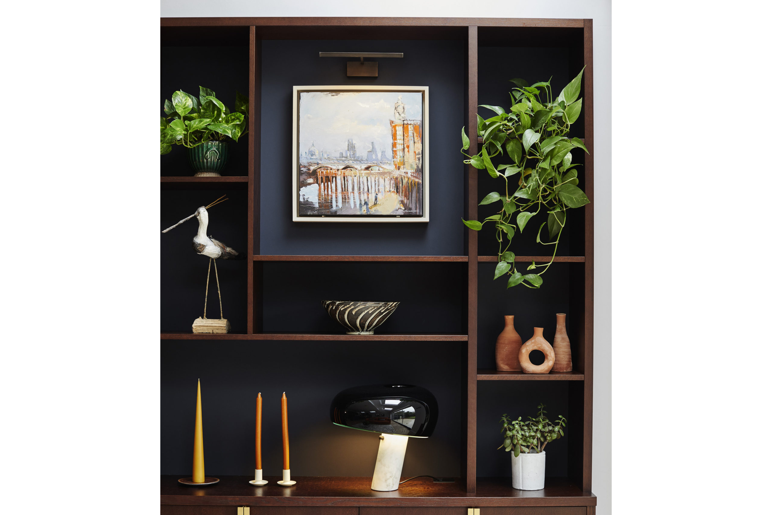 Wooden shelves with plants, art and candles