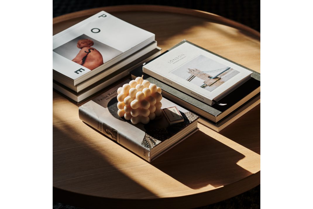 Wooden coffee table. Coffee table books and bubble shaped candle.