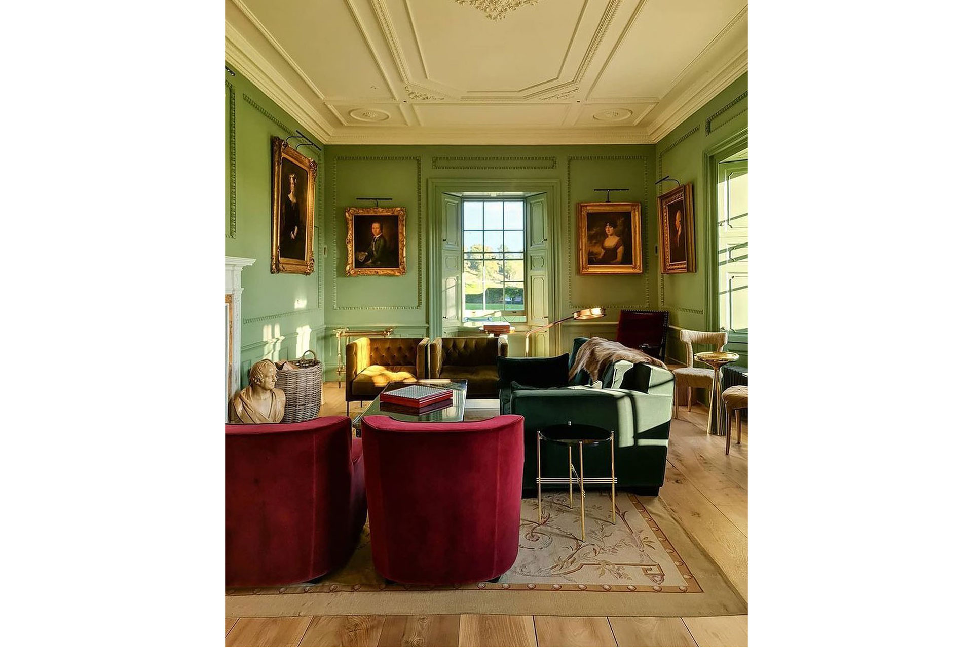 Red chairs green walls at a luxury lounge hotel room at The Newt in Somerset