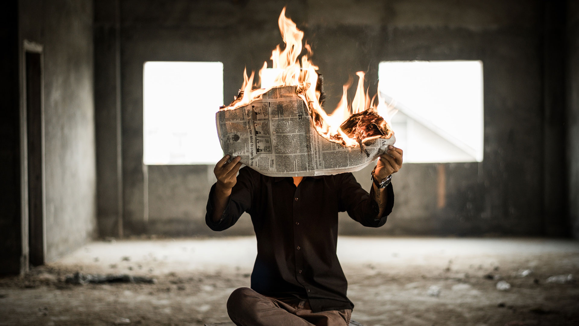 man burning a newspaper