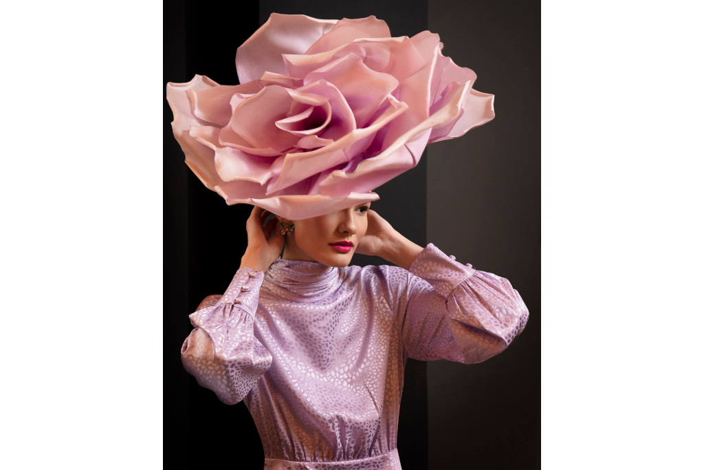 Model wearing pink rose shaped head piece