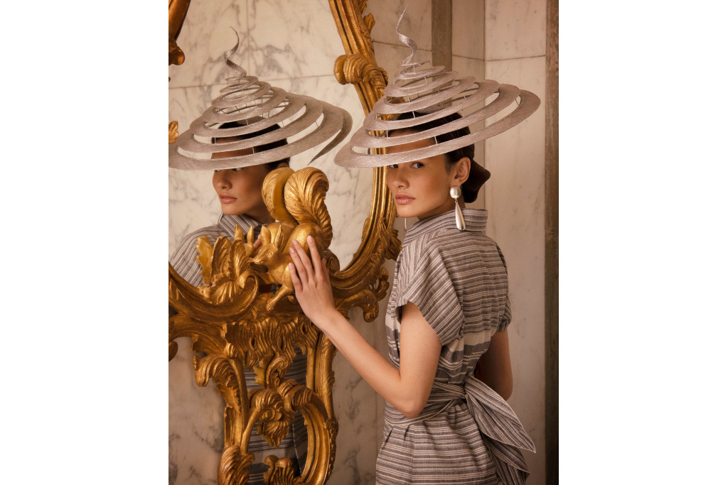 Model looking out as she stands in front of a mirro