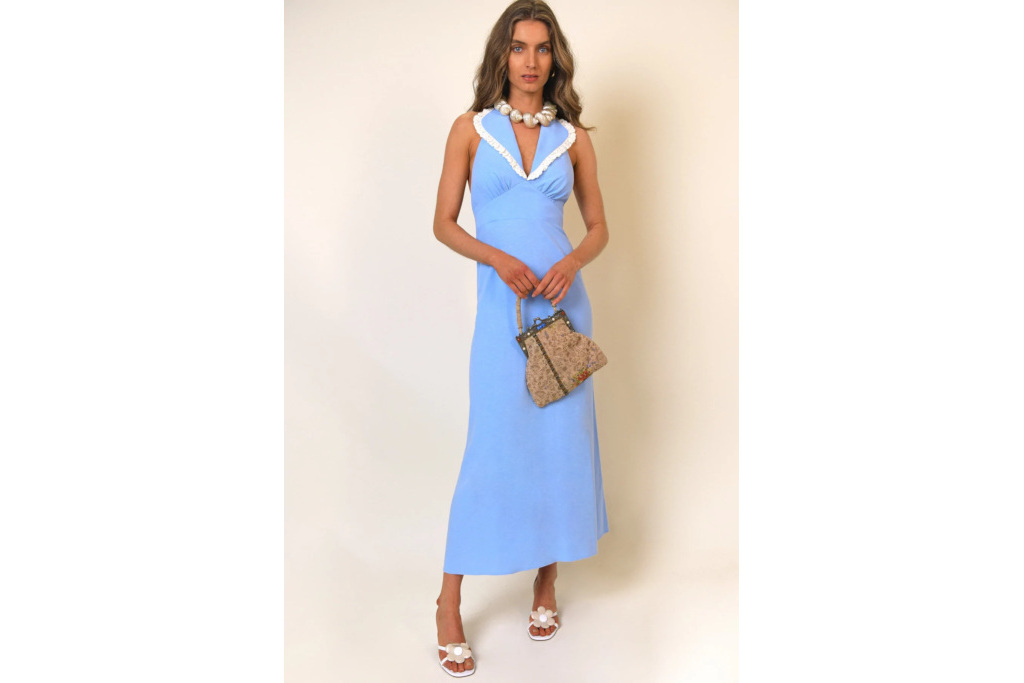 Woman in blue dress stood in front of neutral coloured background
