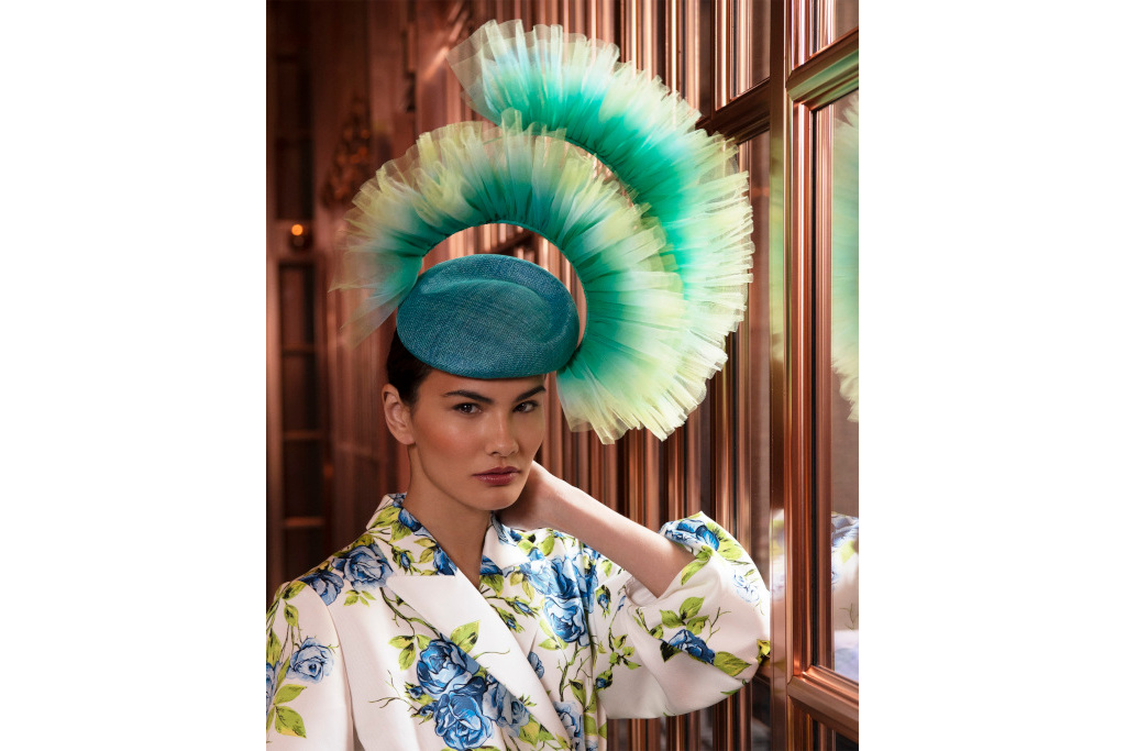 Model in blue and green tulle hat