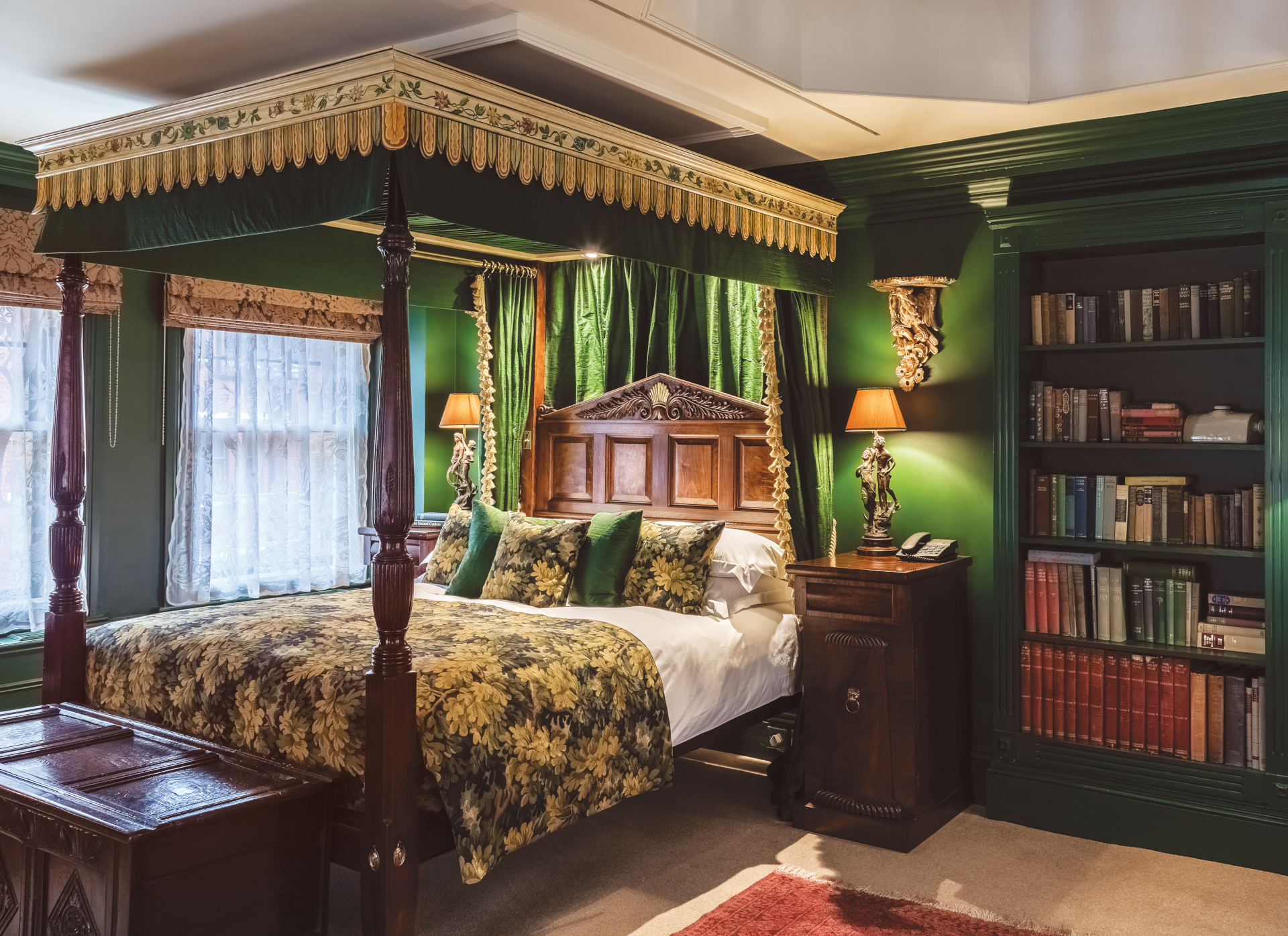 Four poster bed in green coloured room