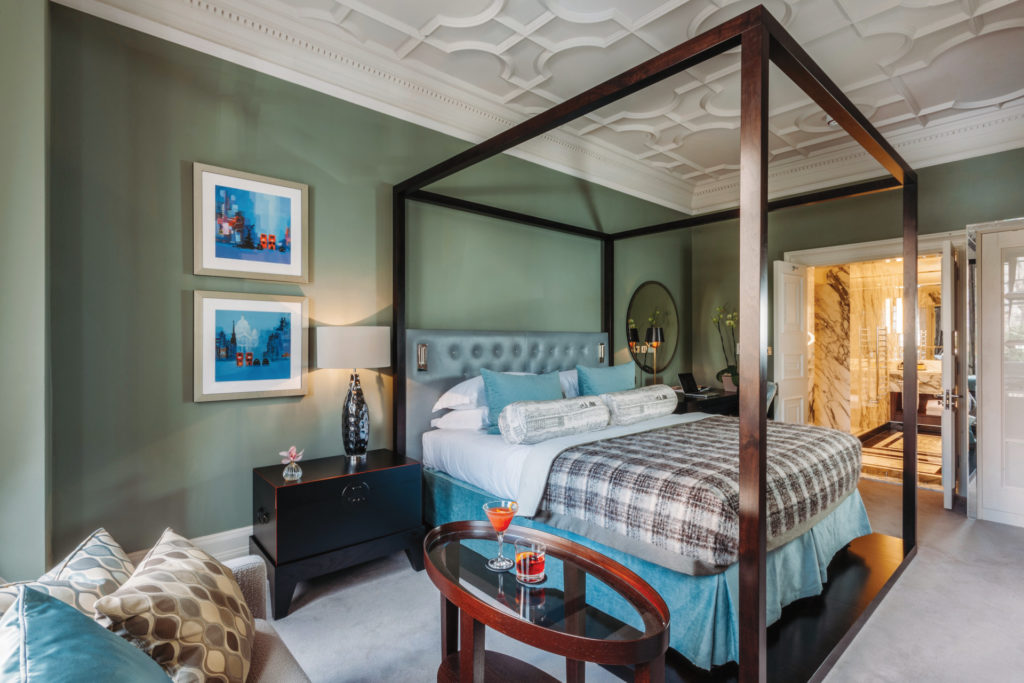 Hotel room with four poster bed and green walls