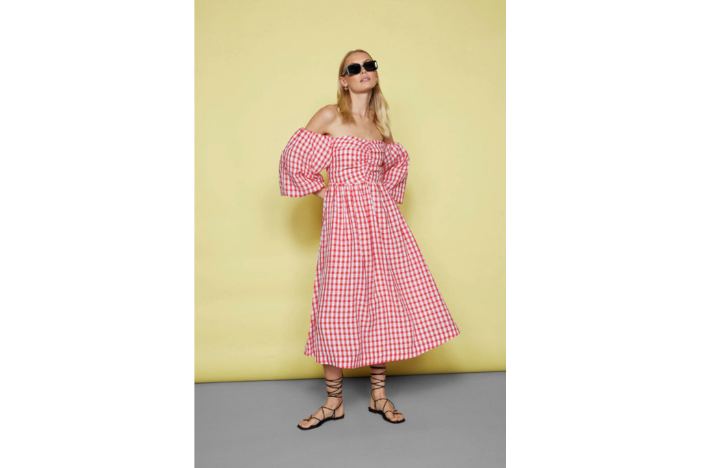 Woman in red gingham dress on yellow background