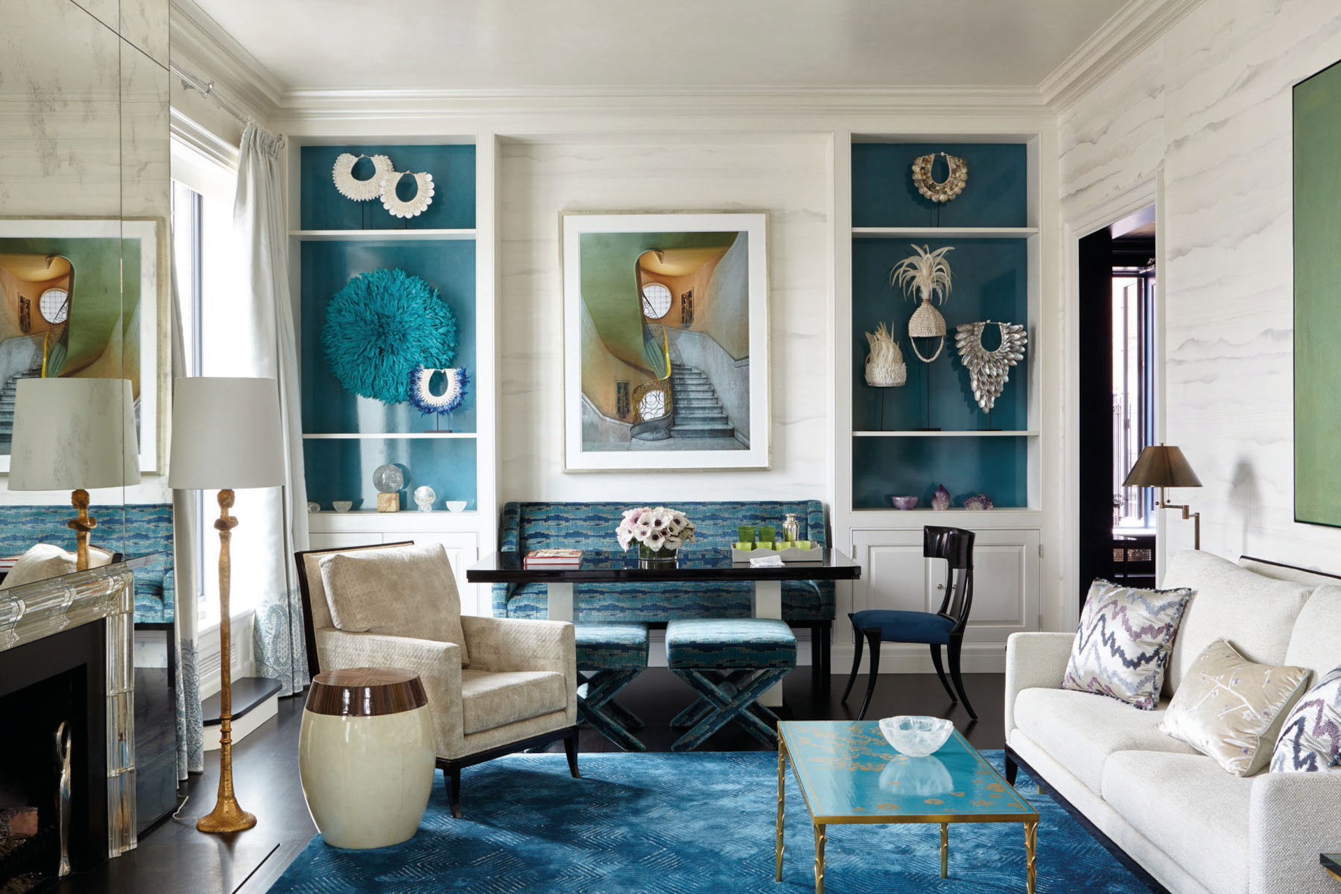 Living room with cream walls and furniture, a blue rug and blue shelving