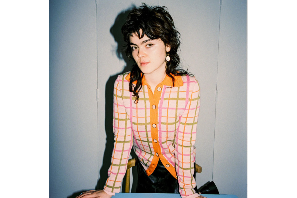 Model in pink and orange check knit top
