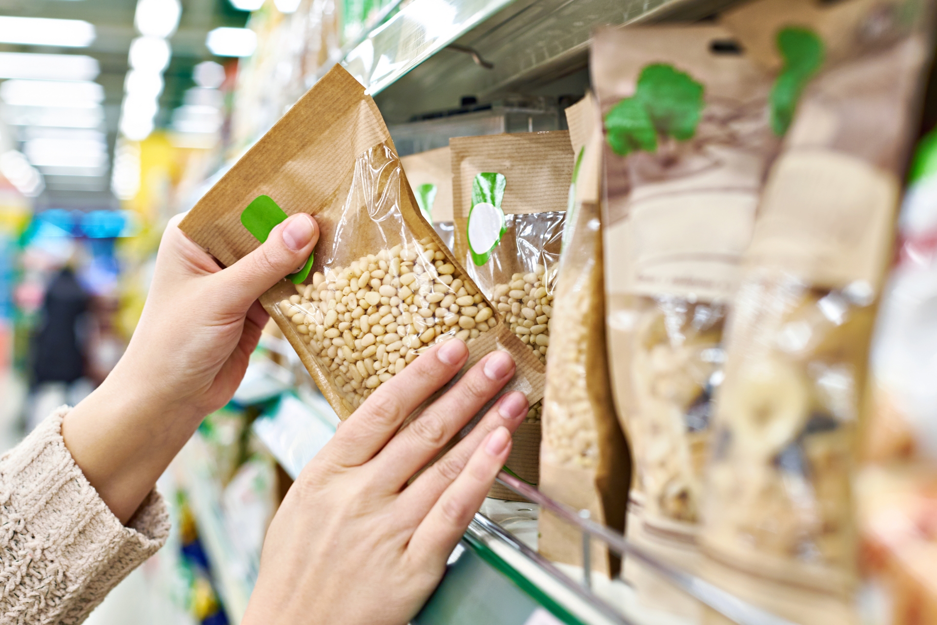 Greenwashing labels - Hands with packaging pine nuts in store