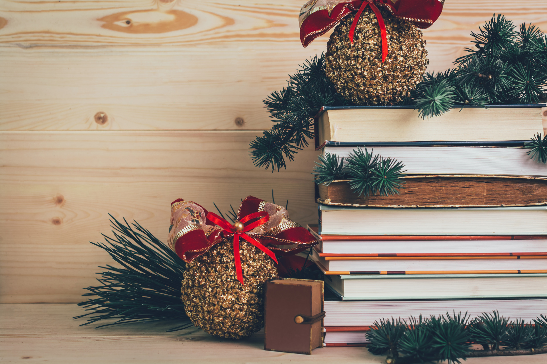 Books-gifts for Christmas with decoration on a wooden background