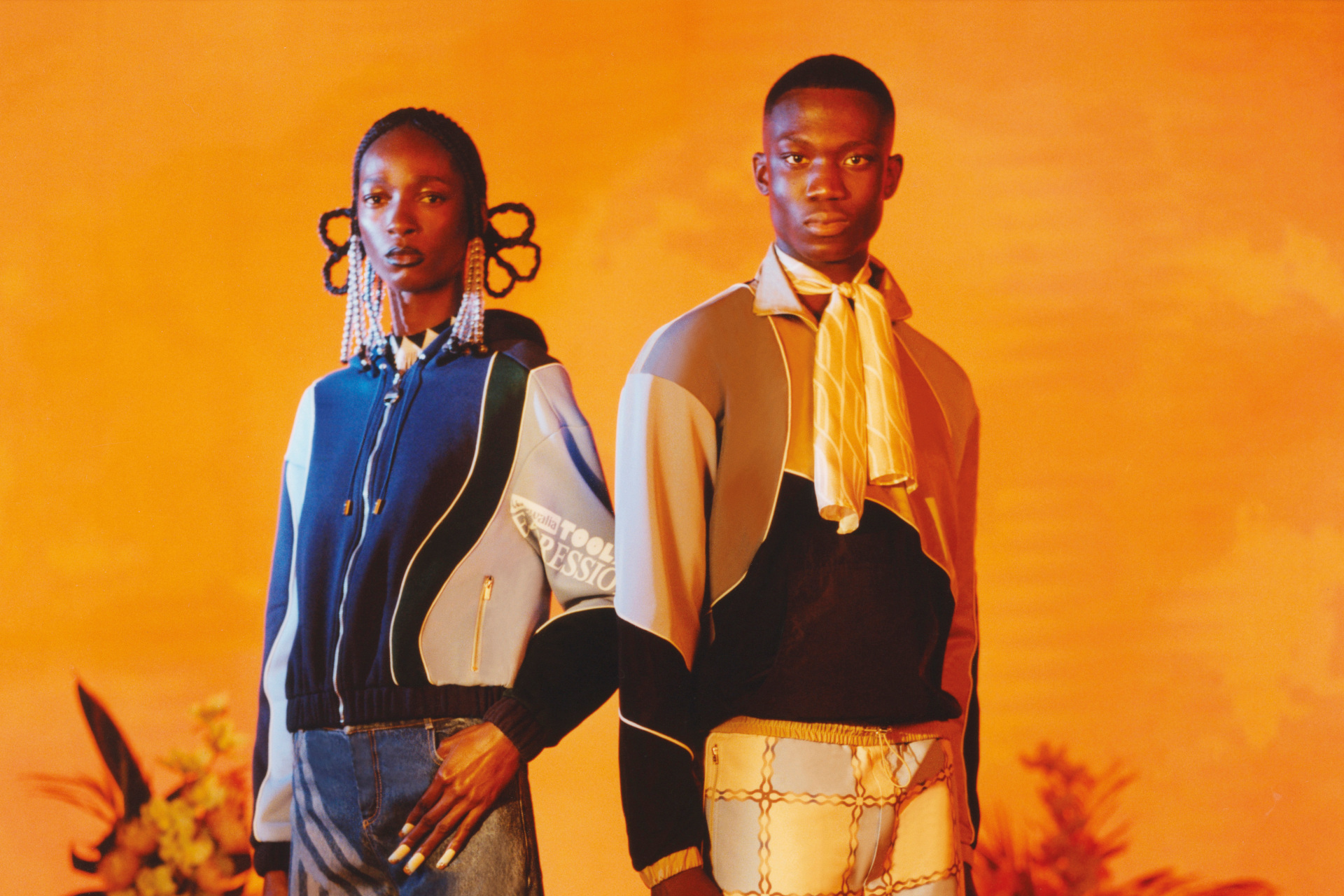 AHLUWALIA lookbook image - two models stood in orange setting (10 BAME Designers To Watch)