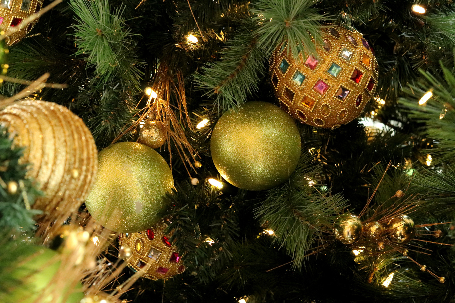 Close up of gold and green baubles on Christmas tree