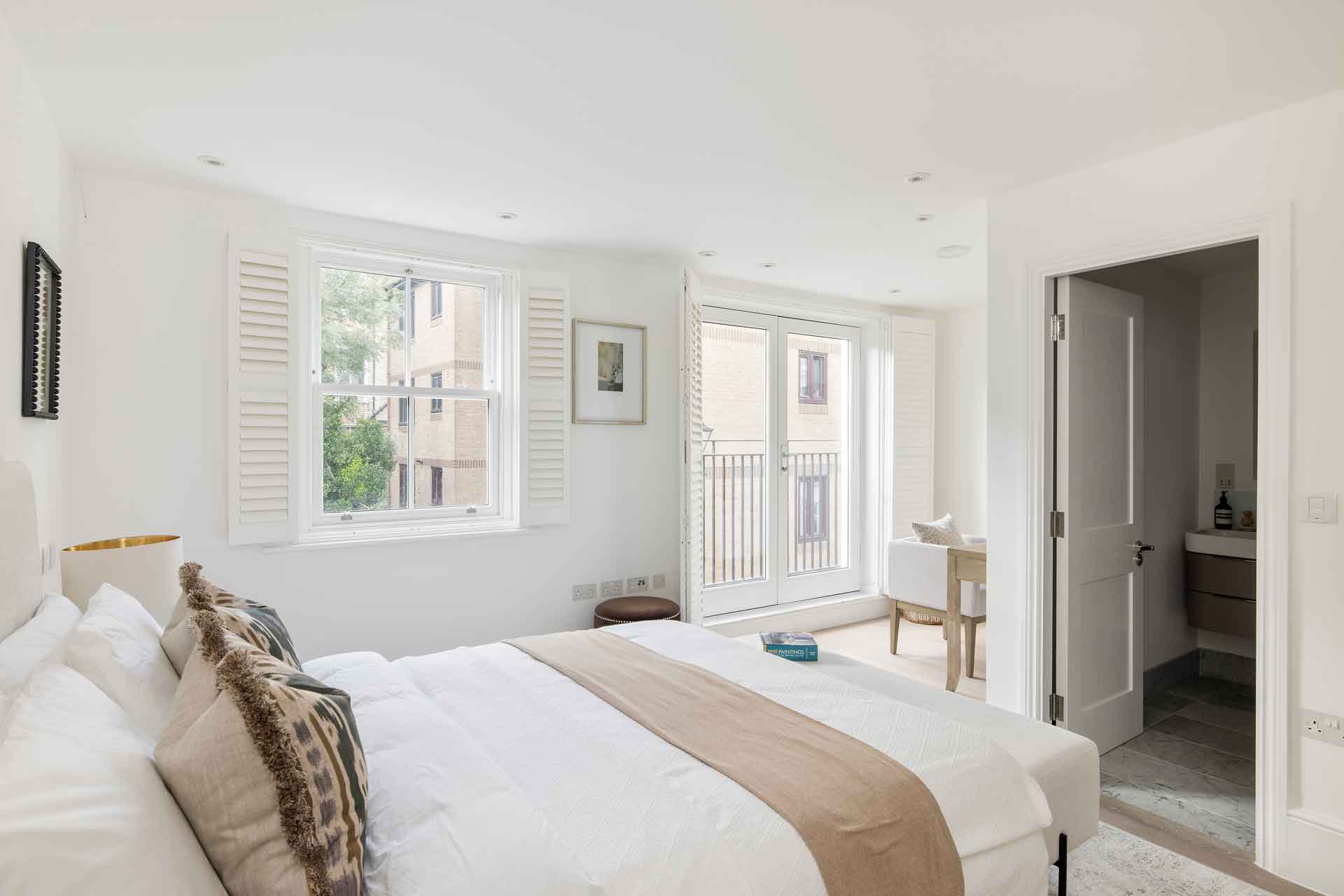 Modern bedroom with white bed linen and taupe accents