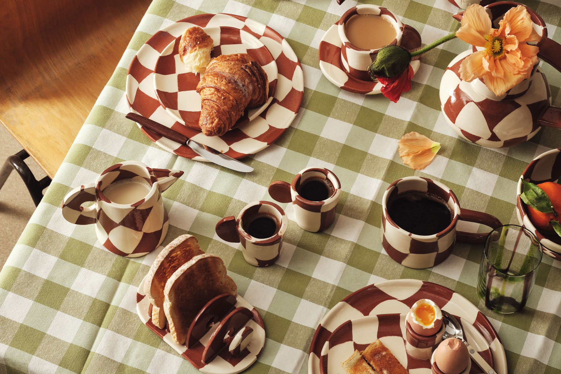 a breakfast scene featuring a birdeye view of red and white chequered crockery and green and white gingham tablecloth