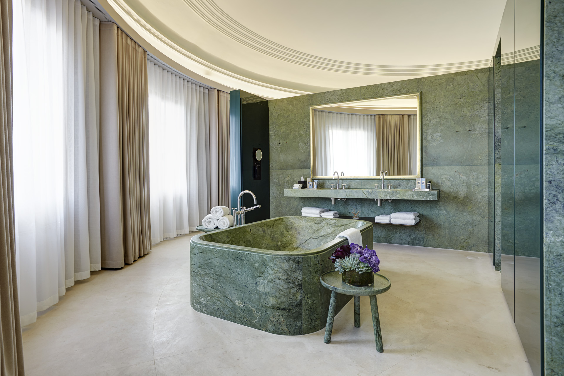 a large bathroom with a green marble tub in the middle